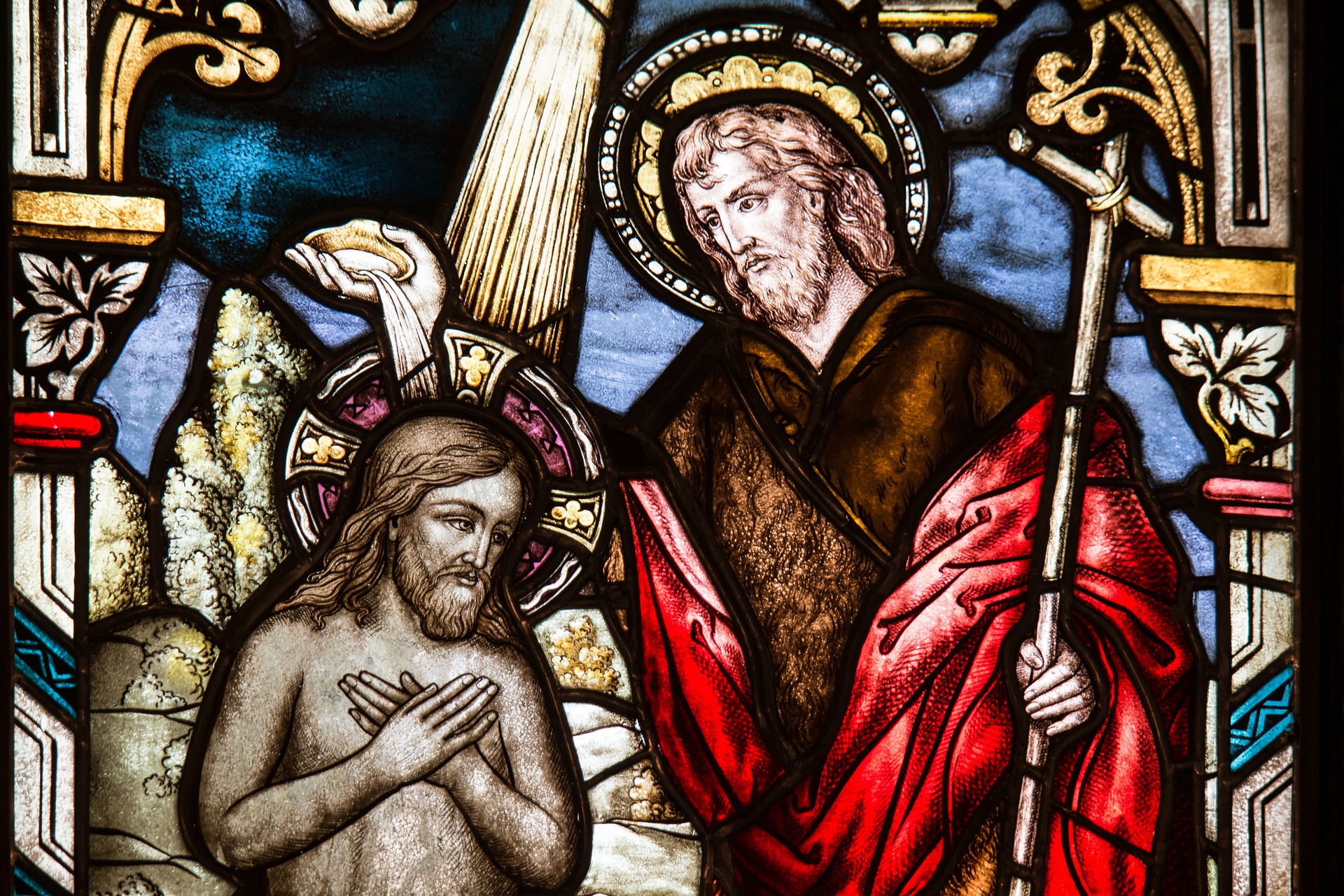 Stained glass showing Jesus being baptised.